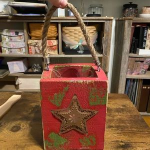 Rustic Red Lantern with star on 2 sides and rope handle.